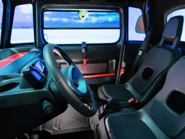 Interni Citroën Ami: volante, sedili neri e un display blu. Un'atmosfera futuristica per la mobilità urbana.