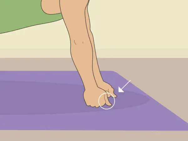 Close-up of hands performing a hand conditioning exercise on a purple mat, with an arrow pointing to the fingers.