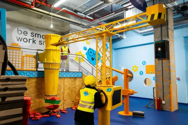 Dzieci budują na Smart Kids Planet w Warszawie. Żuraw i wózek budowlany czekają na małych inżynierów.