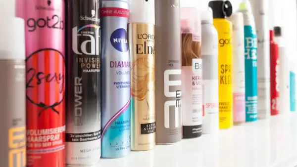 Reihe von Haarspray-Dosen, darunter "got2b 2sexy" und "NIVEA DIAMANT", ideal für Haarspray auf nasse Haare.