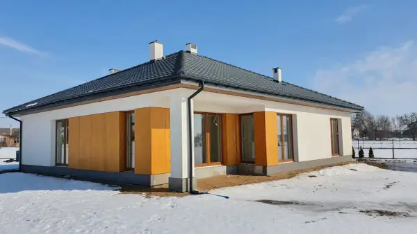 Nowy dom 150 m2 w stanie surowym, otoczony śniegiem. Zastanawiasz się, ile kosztuje wybudowanie domu 150 m2?