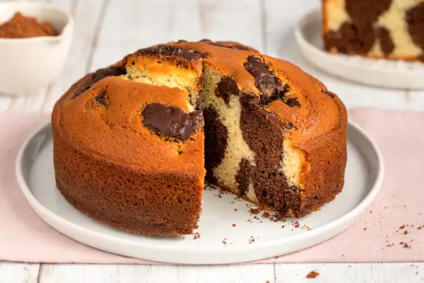 Torta al cioccolato senza burro, con un invitante effetto marmorizzato e una fetta tagliata che ne rivela la morbidezza.