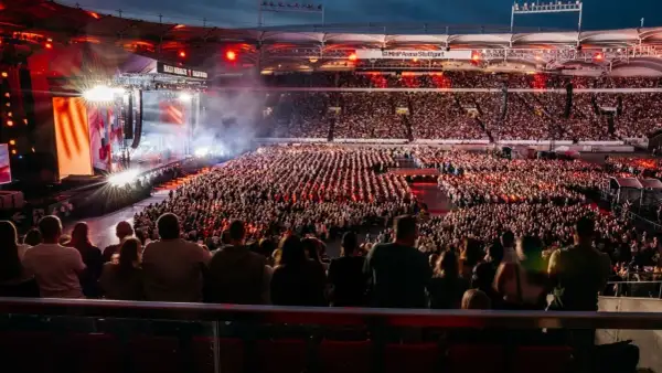 Ein riesiges Publikum feiert bei einem Teddy Show Konzert in der MHP Arena Stuttgart. Die Bühne erstrahlt in bunten Lichtern.