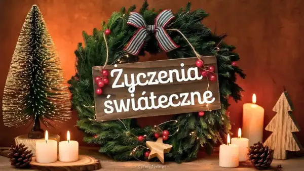 Wianek choinkowy z napisem "Życzenia świąteczne", ozdobiony wstążką, bombkami i lampkami. Obok stoją świece i choinki.