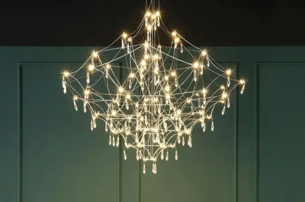 Elegancki żyrandol z kryształkami, przypominający rozgwieżdżone niebo. Każdy klosz emituje ciepłe światło, tworząc magiczną atmosferę.