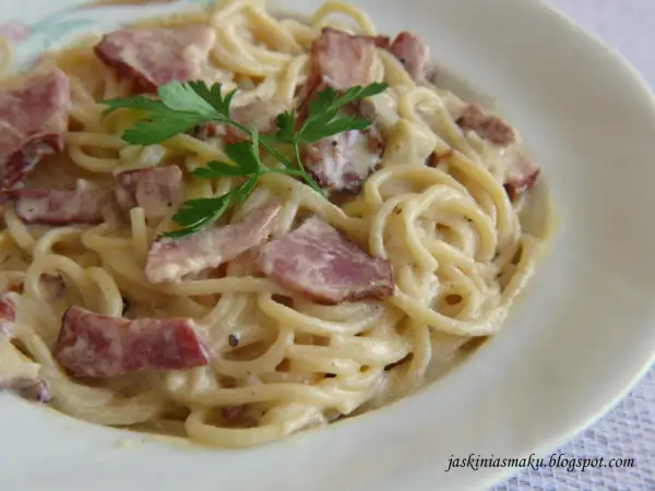 Pyszne spaghetti z boczkiem w kremowym sosie, udekorowane natką pietruszki. Idealne danie dla miłośników włoskiej kuchni.