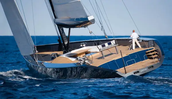 Il Wally Esense naviga con vele spiegate, un uomo al timone. Lusso e velocità sull'onda blu.