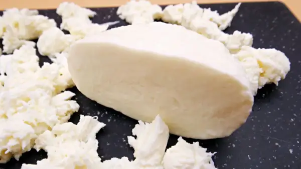 Kawałek mozzarelli light, otoczony postrzępionymi kawałkami sera. Idealna do lekkich sałatek, niskokaloryczna przyjemność.
