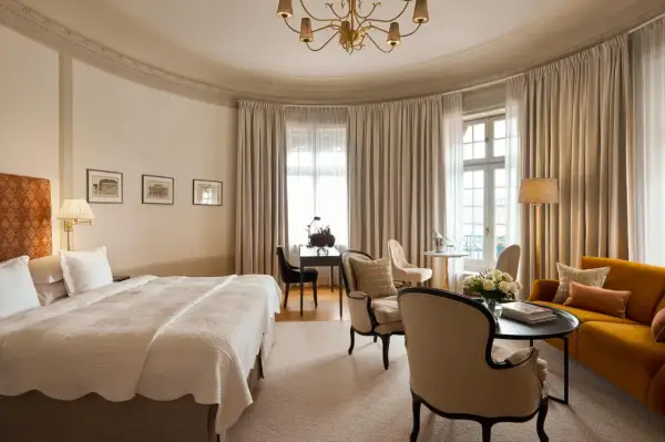 Ett elegant rum på Clarion Hotel Östermalm med en stor säng, soffa, skrivbord och vackra gardiner.
