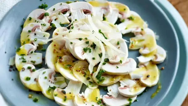 Frische Champignons, mariniert mit einer leichten Vinaigrette, gehobeltem Parmesan und Schnittlauch – eine tolle Idee für Vorspeisen.