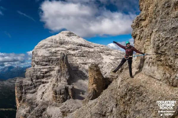 Kobieta na via ferrata w Alpach, pokonująca skalną ścieżkę. Widok na majestatyczne góry, idealne miejsce na via ferrata w Niemczech.