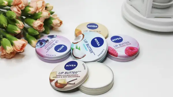 Pięć puszek Nivea Lip Butter: kokosowy, malinowy, jagodowy, waniliowy z makadamią i jeden otwarty. Gdzie kupić te cuda?