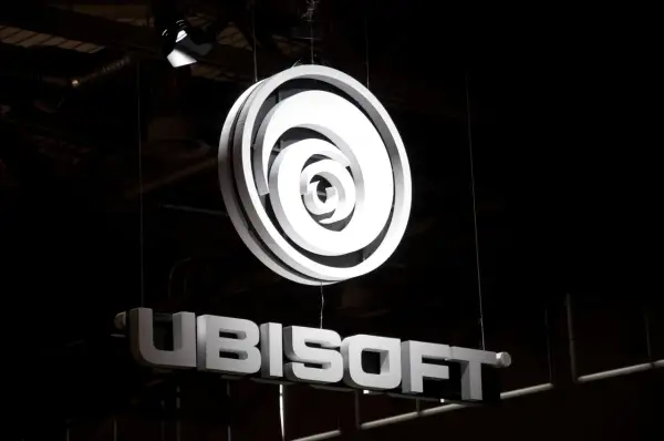 Jasne, oto opis alternatywny:

Podświetlone logo Ubisoft i nazwa firmy wiszą w ciemnym pomieszczeniu. To świetna reklama dla fanów gier Ubisoft akcje.