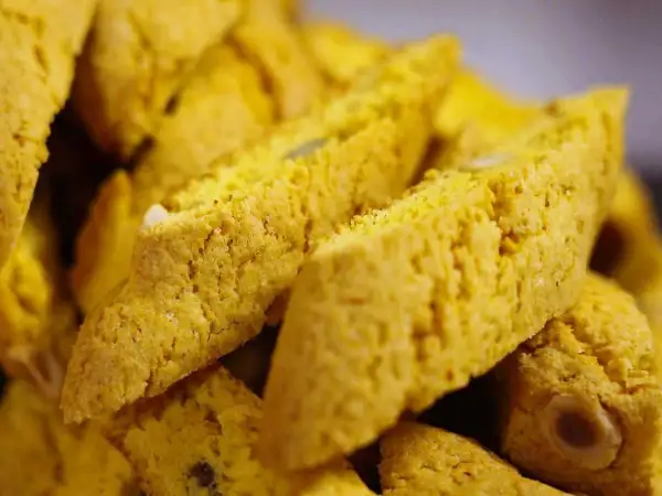Närbild på gyllene saffransbiscotti med mandel, perfekta att doppa i kaffe.
