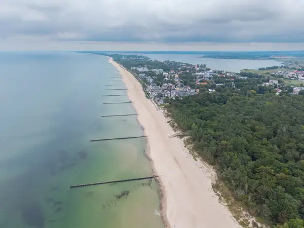 Mielno atrakcje: szeroka plaża, las sosnowy i zabudowania kurortu nad Bałtykiem. Widok z lotu ptaka na wybrzeże.