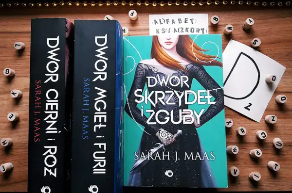 Książki z serii "Dwór cierni i róż" Sarah J. Maas. Tom 6 "Dwór skrzydeł i zguby" z piękną okładką.