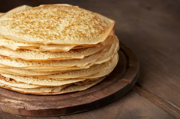 En hög med gyllene pannkakor med havregryn, perfekt för en mysig frukost eller fika.