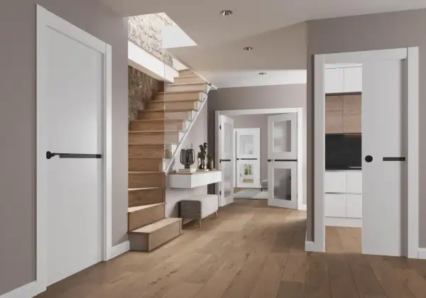 Instalar puerta corredera moderna en un recibidor con escaleras de madera y cocina visible.