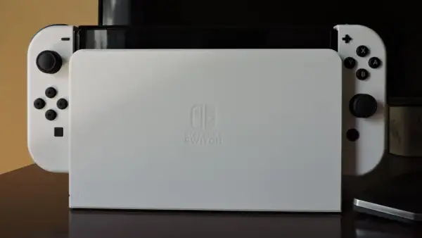 Biała konsola Nintendo Switch z dokiem do podłączenia do TV.