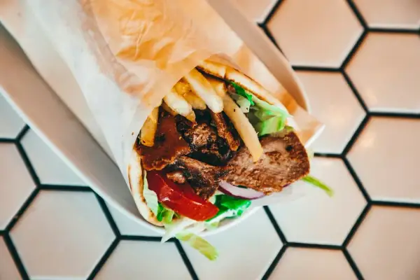 Pyszny kebab z mięsem, frytkami, warzywami i sosem. Zastanawiasz się, ile kalorii ma kebab?