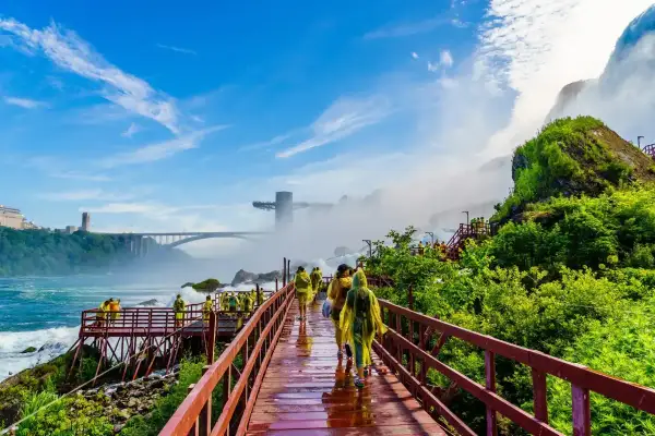Spacerem po drewnianych kładkach podziwiamy potęgę wodospadu Niagara. W oddali widać most i wieżę widokową.
