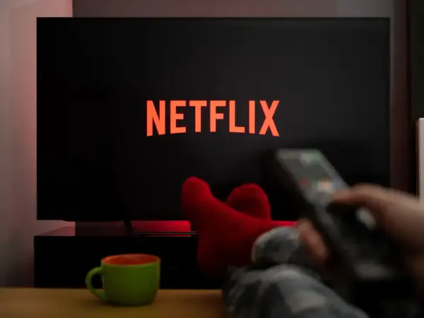 Relaks przy Netflixie. Jak włączyć gry? Czerwone skarpety, pilot w dłoni i kubek napoju.