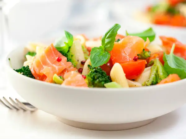 Deliciosa ensalada de pasta con salmón ahumado, brócoli, tomates cherry y albahaca fresca. Un plato ligero y lleno de sabor.