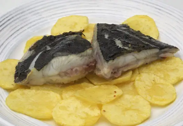 Rodaballo a la plancha servido sobre patatas fritas crujientes. Un plato sencillo y delicioso.