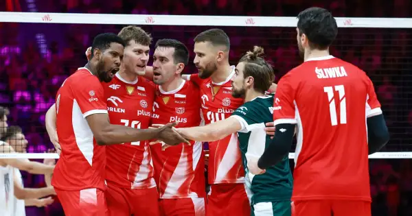 Drużyna Polski w siatkówce świętuje sukces w Lidze Narodów. Zawodnicy w czerwonych strojach z orłem na piersiach cieszą się po wygranej.