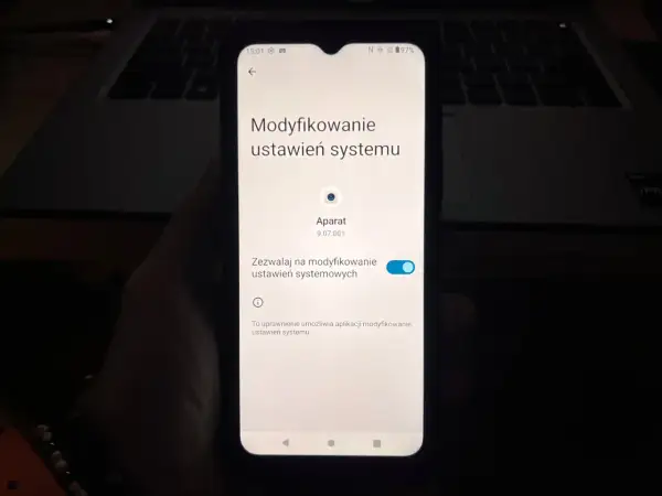 Ekran telefonu pokazuje ustawienia systemu, gdzie można sprawdzić, jak włączyć kamerę w telefonie.