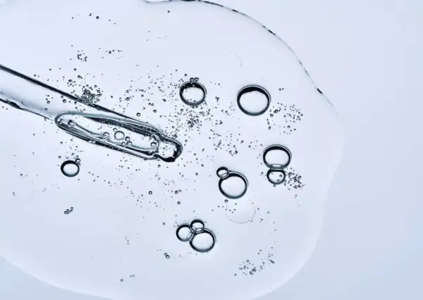Kropla serum z pipetką, bąbelki unoszące się w żelu. Czy peptydy można łączyć z witaminą C? To pytanie nurtuje wiele osób dbających o cerę.