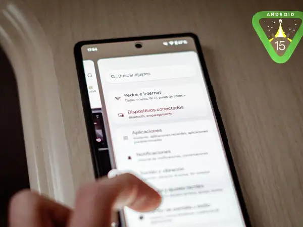 Mano interactuando con un teléfono que muestra la configuración de Android 15. El logo de Android 15 aparece en la esquina superior derecha.