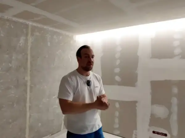 Mężczyzna prezentuje wnękę na led w suficie, która tworzy nowoczesne oświetlenie.