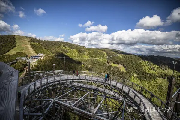 Spacer w chmurach Czechy. Drewniana kładka Sky Bridge 721 w Dolní Moravie wznosi się nad zielonymi lasami i górami.