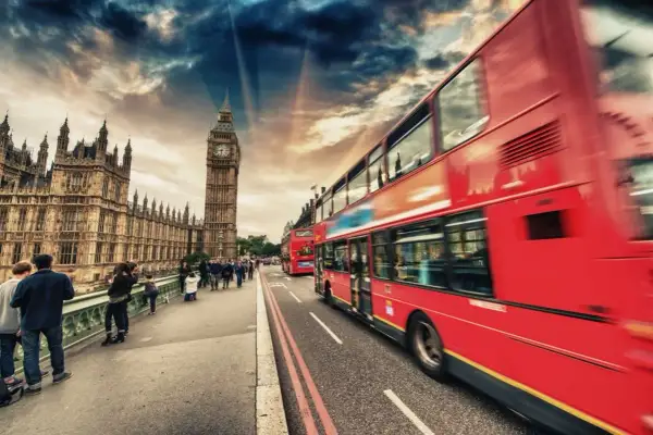Londyn: czerwone autobusy i Big Ben na tle dramatycznego nieba.