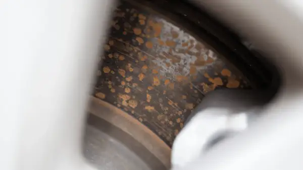Närbild på rostiga bromsskivor med orange fläckar som vittnar om tidens tand.