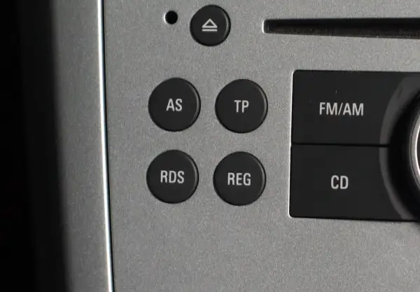 Przyciski radia samochodowego: AS, TP, RDS, REG, FM/AM, CD. RDS to system, który wyświetla dodatkowe informacje o stacji radiowej.