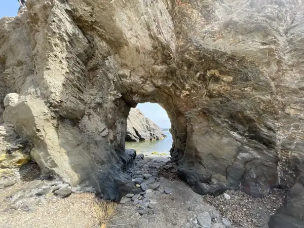 Arco natural en las calas de Villaricos, con el mar azul al fondo y rocas erosionadas.