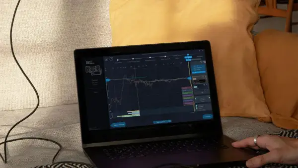Na ekranie laptopa widoczny jest wykres kalibracji dźwięku, prawdopodobnie z użyciem systemu yamaha ypao.