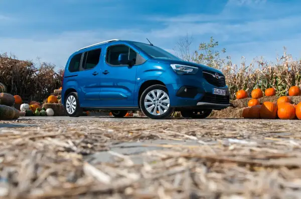Niebieski Opel Combo Life na tle jesiennych dekoracji z dyniami i słomą. Idealny na rodzinne wycieczki.
