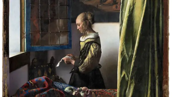 A woman in a yellow and black dress reads a letter by a window, a scene from one of Vermeer's famous paintings of women.