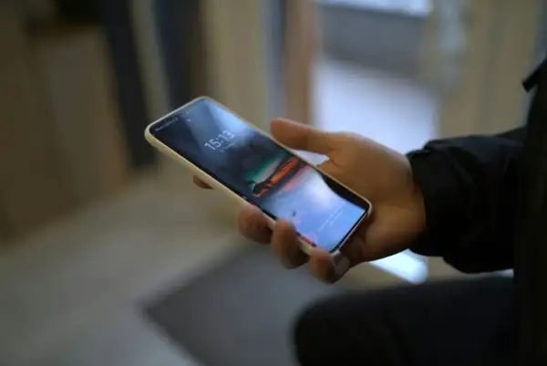 Dłoń trzyma smartfon Samsung. Chcesz wiedzieć, jak wyłączyć dźwięk klawiatury Samsung?