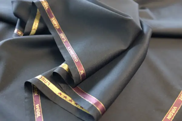 Elegancka, czarna wełna z metką "Super 120's Virgin Wool". Idealna na garnitur.