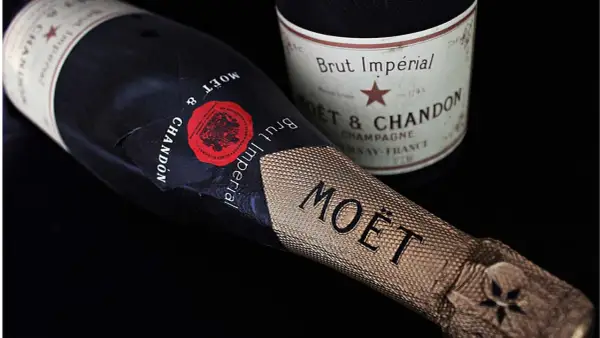 Dwie butelki szampana Moët & Chandon Brut Impérial na czarnym tle. Zastanawiasz się, ile szampan ma procent? Zwykle 12%.