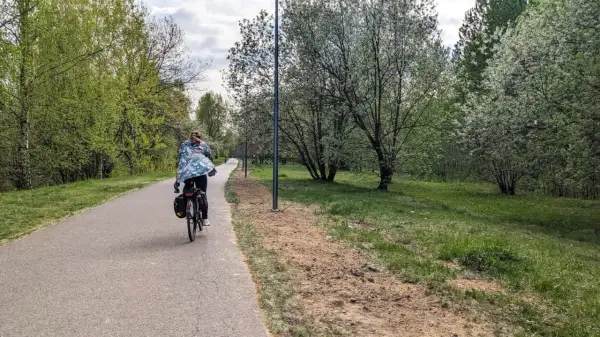 Osoba na rowerze jedzie ścieżką wzdłuż zielonego parku. To piękna pogoria 3 trasa, idealna na wiosenną przejażdżkę.