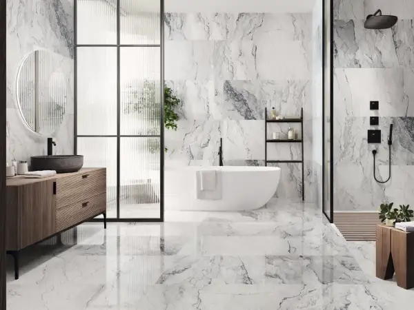 Elegantes combinaciones de azulejos para baños con efecto mármol, bañera exenta y mueble de madera.