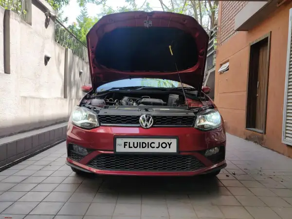 Czerwony VW Polo z otwartą maską, gotowy do wymiany żarówki H7.