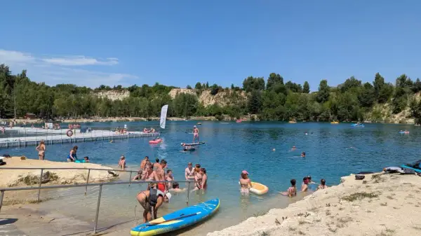 Ludzie kąpią się i pływają na deskach SUP w słoneczny dzień nad zalewem Balaton Trzebinia.