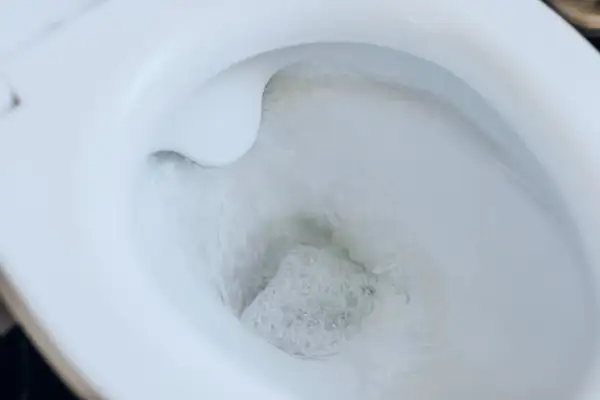 Woda spływa do muszli klozetowej, tworząc bąbelki. Dowiedz się, jak odepchać toaletę, gdy woda stoi.