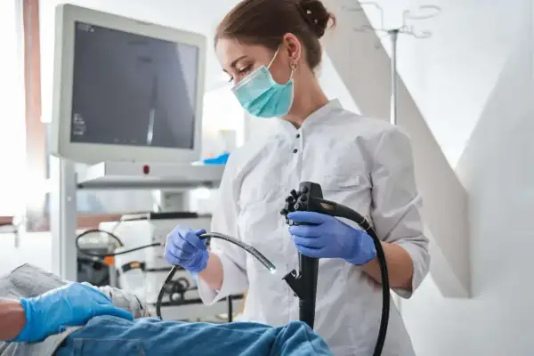 Lekarka w masce przygotowuje się do gastroskopii. Po zabiegu warto unikać alkoholu, by organizm mógł się zregenerować.